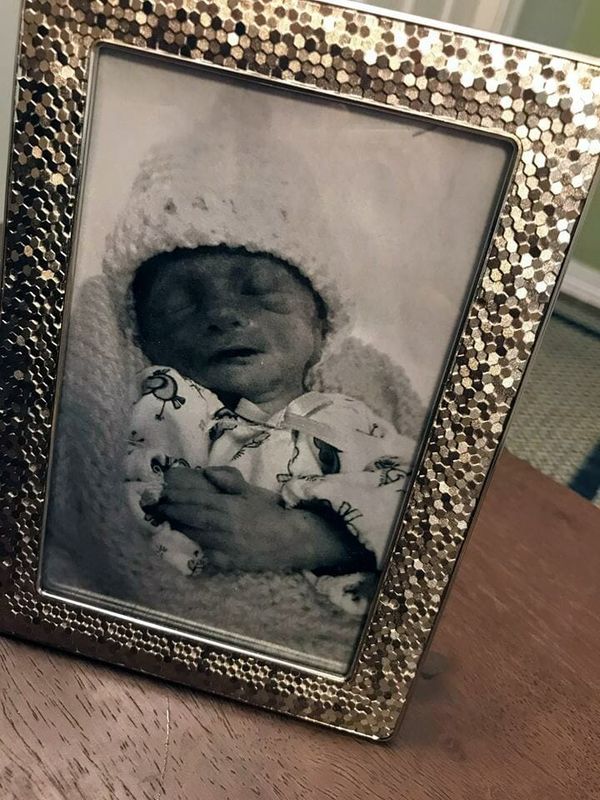 Nurse dressing a baby and taking a photo