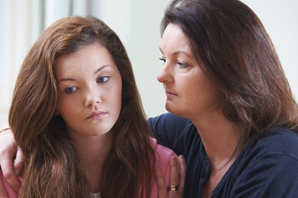 Mother comforting teenage daughter