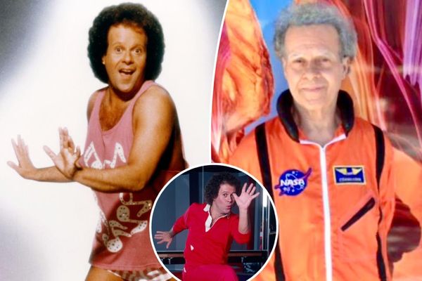 Richard Simmons smiling in a bright orange NASA suit