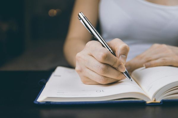 A woman writing in a notebook | Source: Pexels